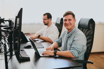 Wall Mural - Portrait of two professional male programmers working on computer in diverse offices. Modern IT technologies, development of artificial intelligence, programs, applications and video games concept