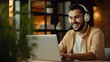 © JW Studio - Happy man student wearing headphones study online using laptop on blurred home background.