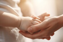 Mother Holding Baby Hand, Cinematic Tones, Parent Taking Care Of The Child. New Parenthood Concept