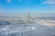 Aerial view of lush snow-covered woods with Avala Tower in the background. Beli Potok, Serbia.