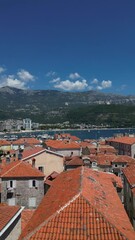 Wall Mural - Ascending drone over traditional roof houses of Kotor town by the Adriatic sea in Montenegro