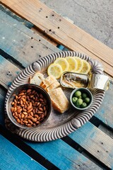 Sticker - Top view of a tinned fish sardines snack platter with lemons, almonds, and olives