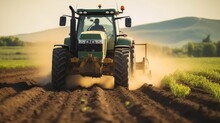Farmer Using A Tractor And Planting Implement, Plants Potatoes In The Fertile Farm Fields.