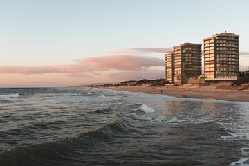 Sticker - the waves are coming into the beach next to a pair of towers