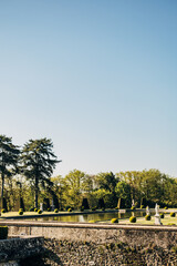 Poster - Vertical shot of the garden of the Chateau de Breteuil in Choisel, France in blue sky background