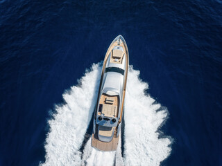Wall Mural - aerial top view of a luxury yacht cruising with high speed over blue ocean