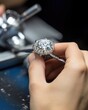 A closeup view of a jeweler expertly setting a sparkling diamond into a white gold engagement ring, delicately pushing down each prong to securely hold the gemstone in place.