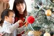 © amanaimages - クリスマスツリーの飾り付けをする親子