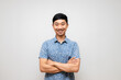 Positive asian man blue shirt happy smile and crossed arm portrait isolated
