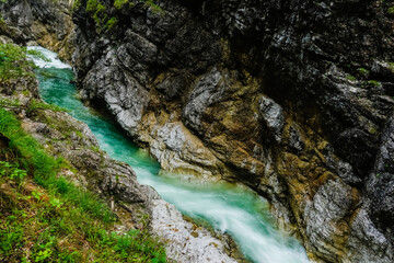 green white rushing water in a gorge with high rock face during hiking in salzburg