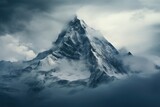 Fototapeta Góry - Mountain top covered with snow and shrouded in clouds at dawn