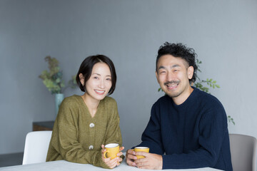 Wall Mural - A couple sitting in dining room chairs looking at the camera