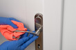 Klamka od drzwi łazienki wycierana ściereczką, dezynfekcja bakterii