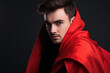 Handsome Man in Red Cape on a Black Background