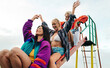 © Jacob Lund - Fun with friends: Three women sliding down a slide at a play park