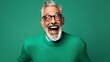 © Suleyman - Older man in a green pullover and glasses in a picture of retirement against a blue color background.