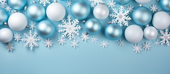 Poster - Winter themed arrangement featuring white balls snowflakes on pastel blue Holiday winter new year motif Overhead view space for text