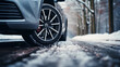 Car tires on winter snowy road covered with snow, low angle side view