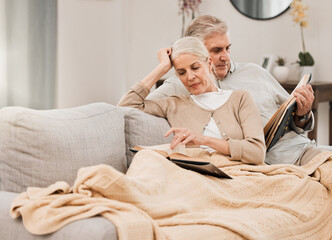 Canvas Print - Old couple on couch, reading book and relax together at home, retirement and wellness with love and comfort. Trust, care and support in marriage, share hobby with partner for knowledge and story