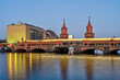 The beautiful Oberbaumbruecke in Berlin with a yellow metro train at dusk