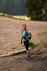 Wall Mural - Woman hiking on a trail in the mountains