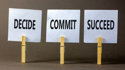 Wall Mural - Decide commit succeed symbol. Concept word Decide Commit Succeed on beautiful white paper on wooden clothespin. Beautiful grey table grey background. Business decide commit succeed concept. Copy space