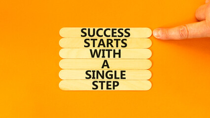 Wall Mural - Success symbol. Concept words Success starts with a single step on wooden stick. Beautiful orange background. Businessman hand. Business success starts with a single step concept. Copy space.