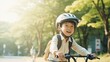 Cute little asian boy having fun by riding bicycle. Cute kid in safety helmet biking outdoors. natural light.
