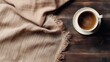 A cup of hot coffee on an old wooden table, seen from above with empty space as a background for words or promotional items. Perfect for winter themed designs, coffee shops and relaxation designs.
