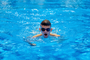 Fit swimmer training in the swimming pool. An overhead view of a man diving into a pool, forming an arrow shape and leaving a trail behind him. Professional male swimmer inside swimming pool. Young