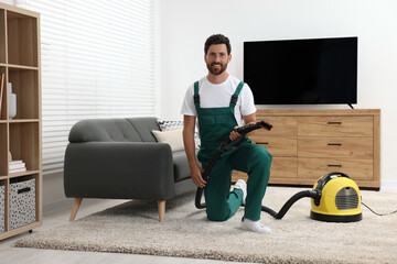 Wall Mural - Dry cleaner's employee with vacuum cleaner on carpet in room