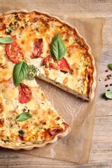 Wall Mural - Tasty quiche with tomatoes, basil and cheese on wooden table, flat lay