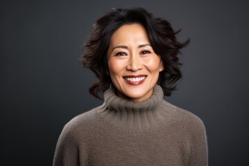 Canvas Print - Close-up portrait photography of a Vietnamese woman in her 50s wearing a cozy sweater against a black background