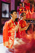 © topntp - Happy young Asian couple in Chinese traditional dresses praying at temple