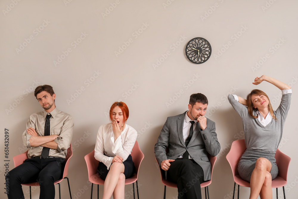 Tired young applicants waiting for job interview in room