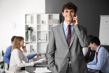 Wall Mural - Male business consultant talking by mobile phone in office