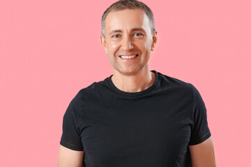 Wall Mural - Portrait of happy mature man on pink background