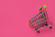 Leinwandbild Motiv Shopping cart on pink background