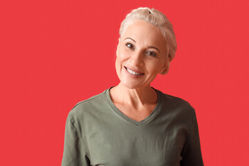Wall Mural - Mature woman on red background, closeup