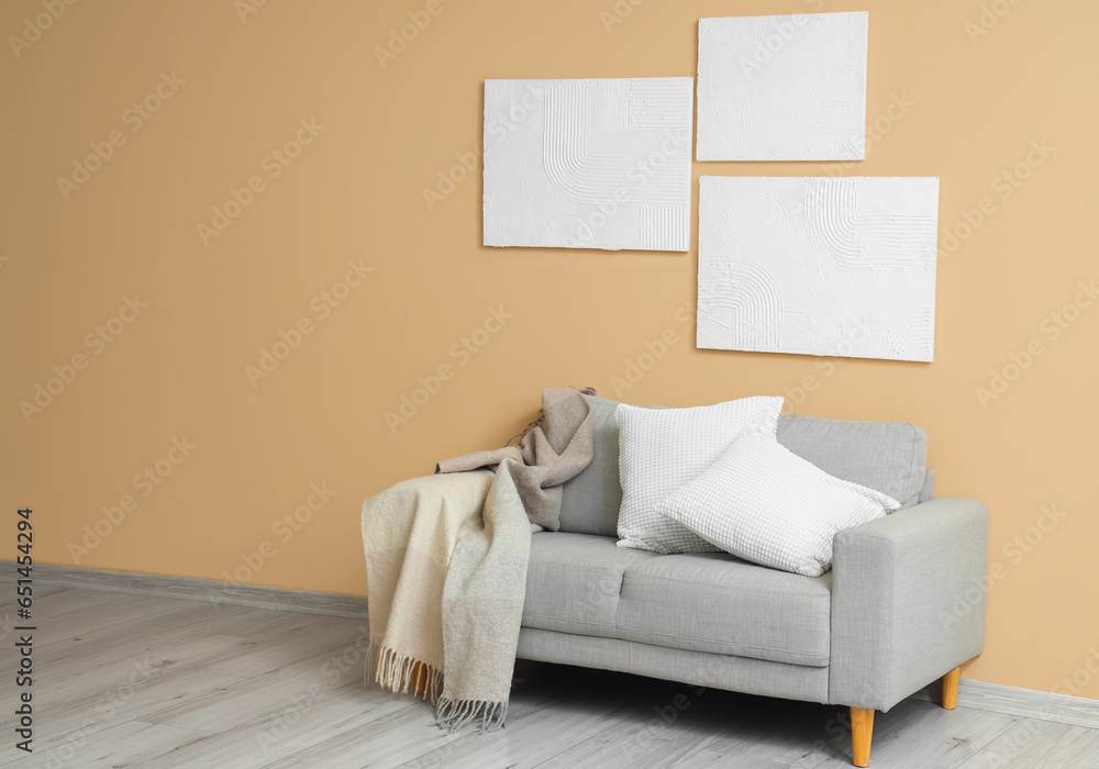 Interior of living room with grey sofa and paintings