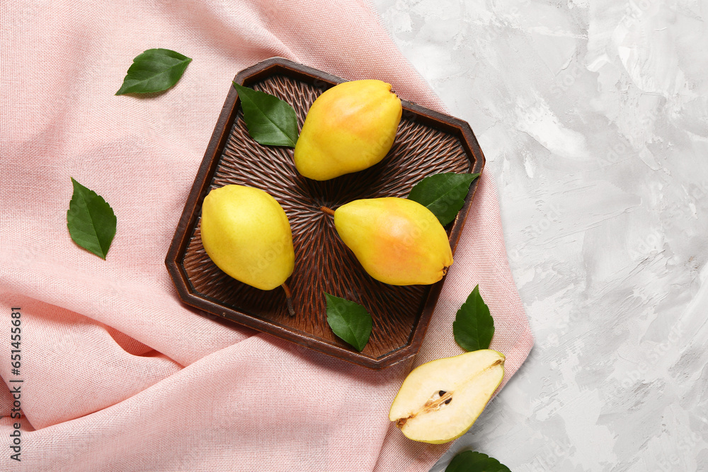 Tray with fresh pears and leaves on grey background
