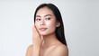 © JKLoma - A beautiful asian female model, one hand stroking her cheek, on a white background.