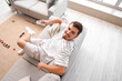 © Pixel-Shot - Young man switching on air conditioner at home