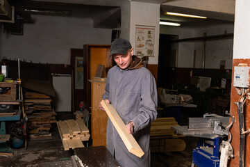 Wall Mural - A craftsman works on woodworking machines and saws in a furniture workshop