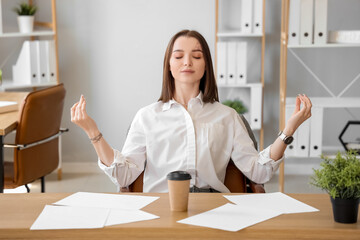 Wall Mural - Young businesswoman meditating in office