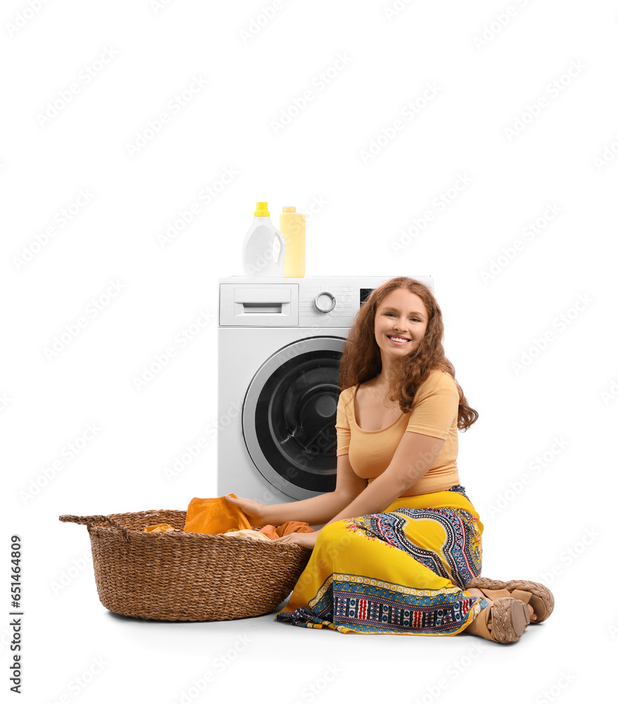 Young woman with laundry basket and washing machine sitting on white background