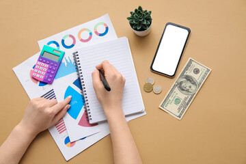 Canvas Print - Female hands with notebook, calculator, charts and smartphone on beige background. House rent concept