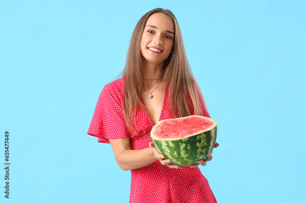 Young woman with fresh watermelon on blue background