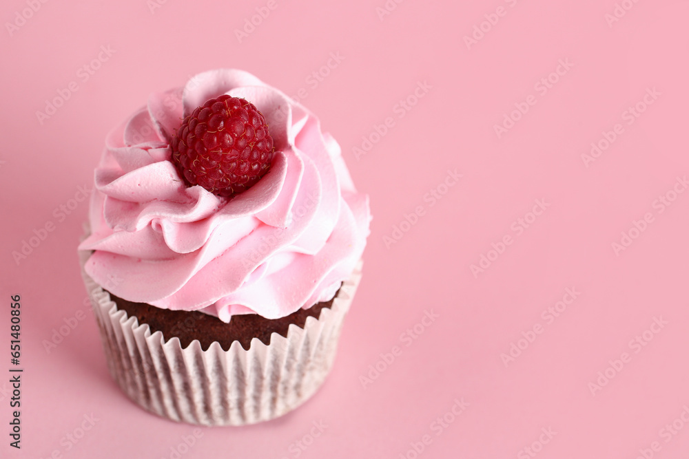 Tasty raspberry cupcake on pink background
