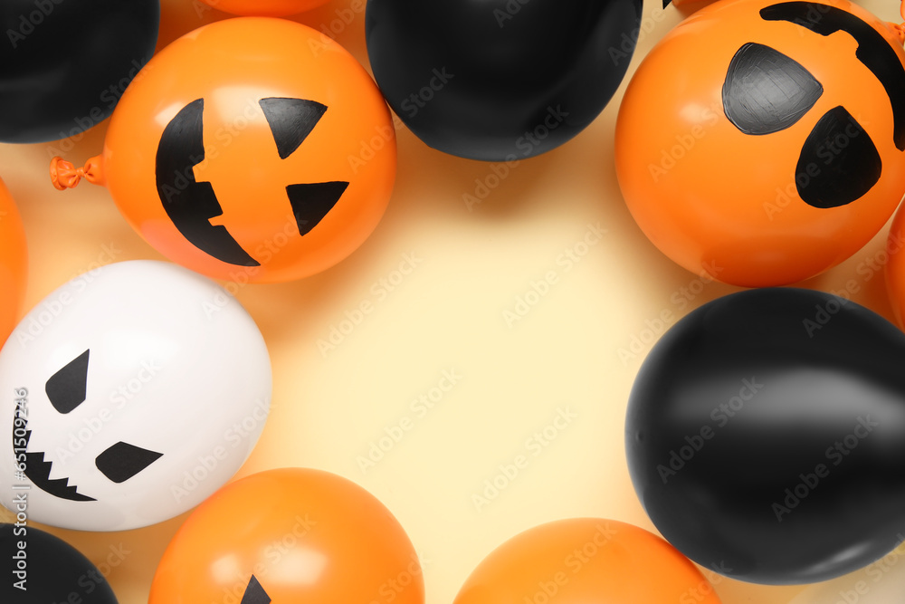 Frame made of different funny Halloween balloons on yellow background